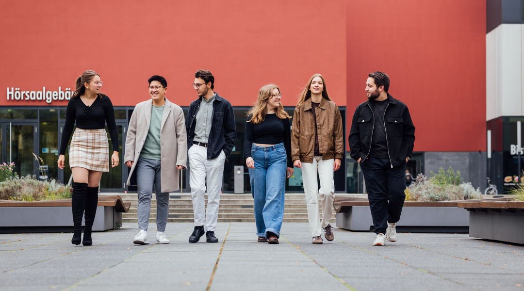 Gruppenbild der Studienbotschafter:innen laufend auf dem Campus, Foto: Christian Hüller