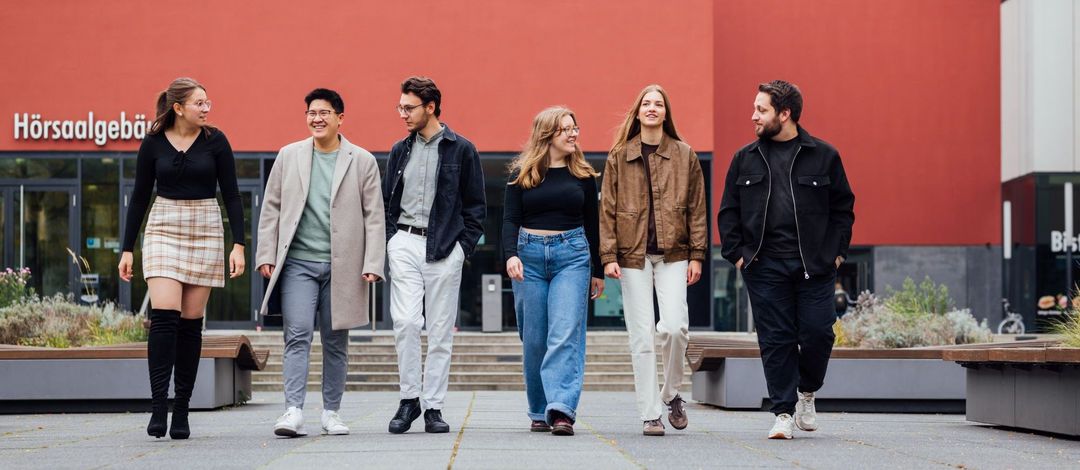 Gruppenbild der Studienbotschafter:innen laufend auf dem Campus, Foto: Christian Hüller